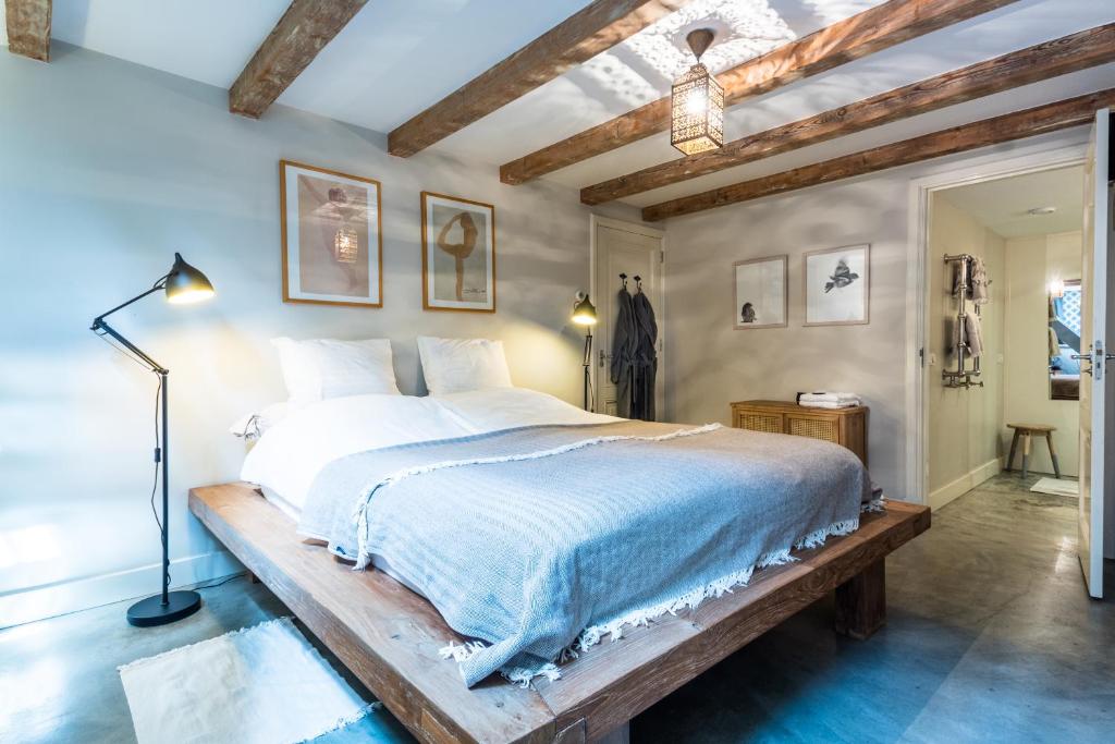 阿姆斯特丹阿姆斯特丹阿姆斯特尔住宿加早餐公寓的一间卧室配有一张木架大床