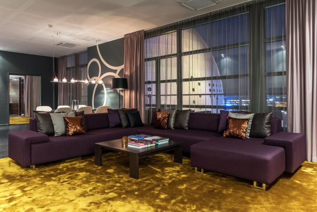 斯德哥尔摩品质环球酒店的客厅配有紫色沙发和桌子