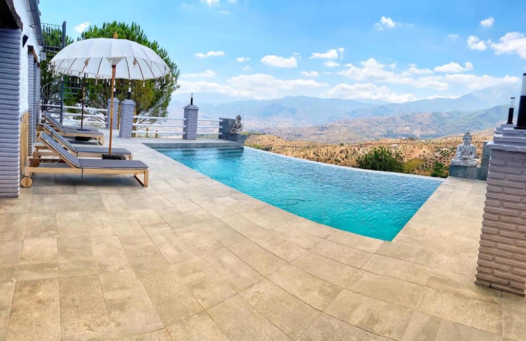 马拉加Casa Eden - Mountain View, Infinity Pool的一个带遮阳伞、椅子和遮阳伞的游泳池