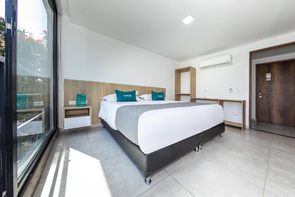 麦德林Ayenda Zona Verde的一间卧室设有一张大床和一个大窗户