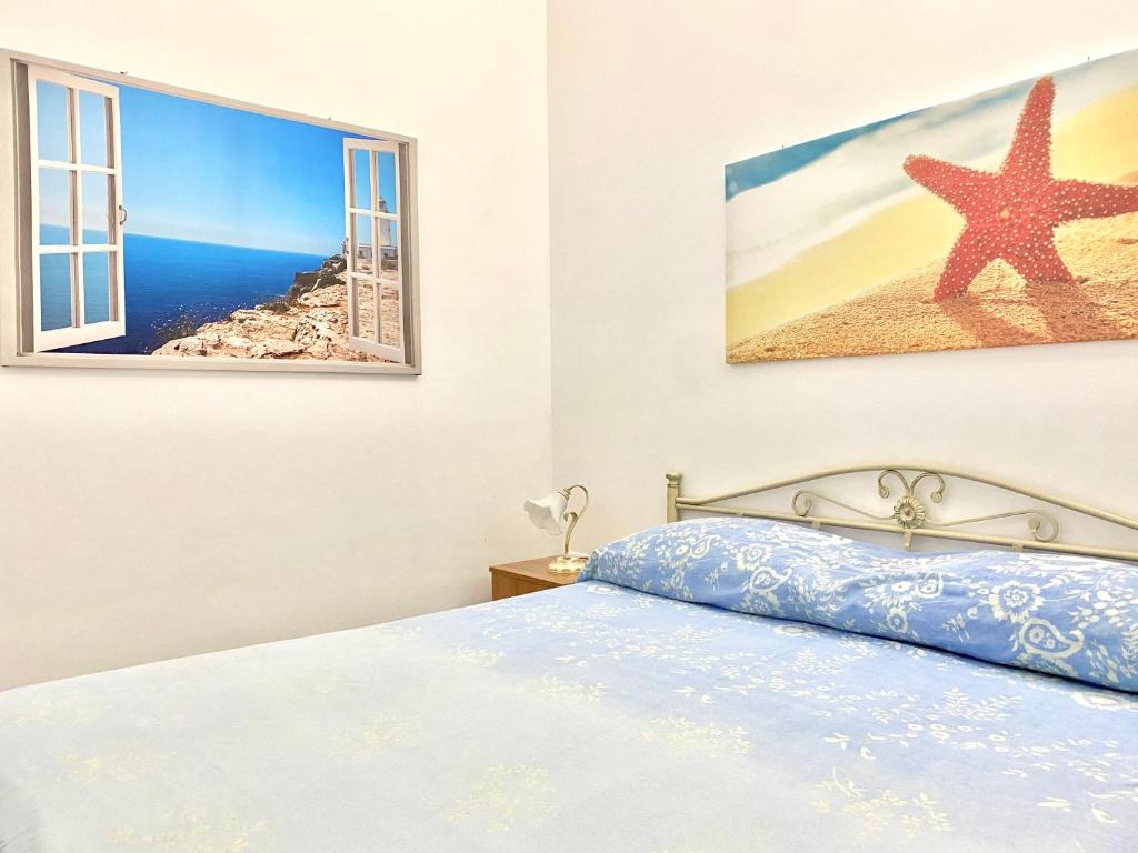 帕图Baia Salentorelax San Gregorio的一间卧室配有一张床,享有海滩美景