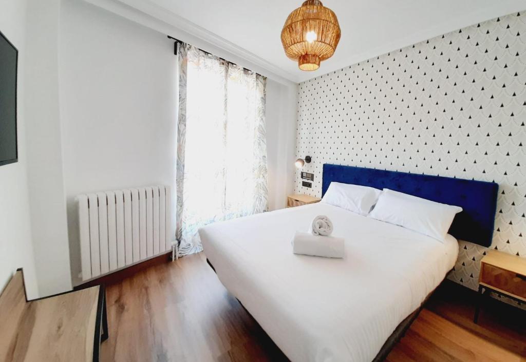 萨拉曼卡Hotel Matilde by gaiarooms的一间卧室配有一张白色大床和蓝色床头板