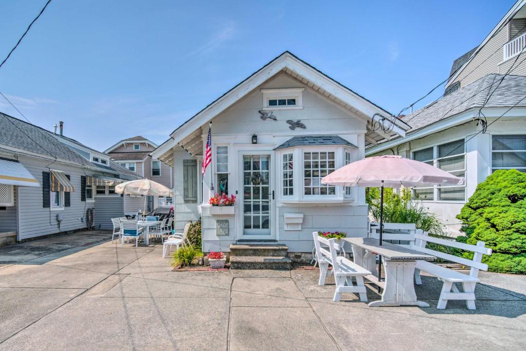 大洋城Darling Ocean City Cottage, 2 Blocks to Beach!的前面有桌子和遮阳伞的房子