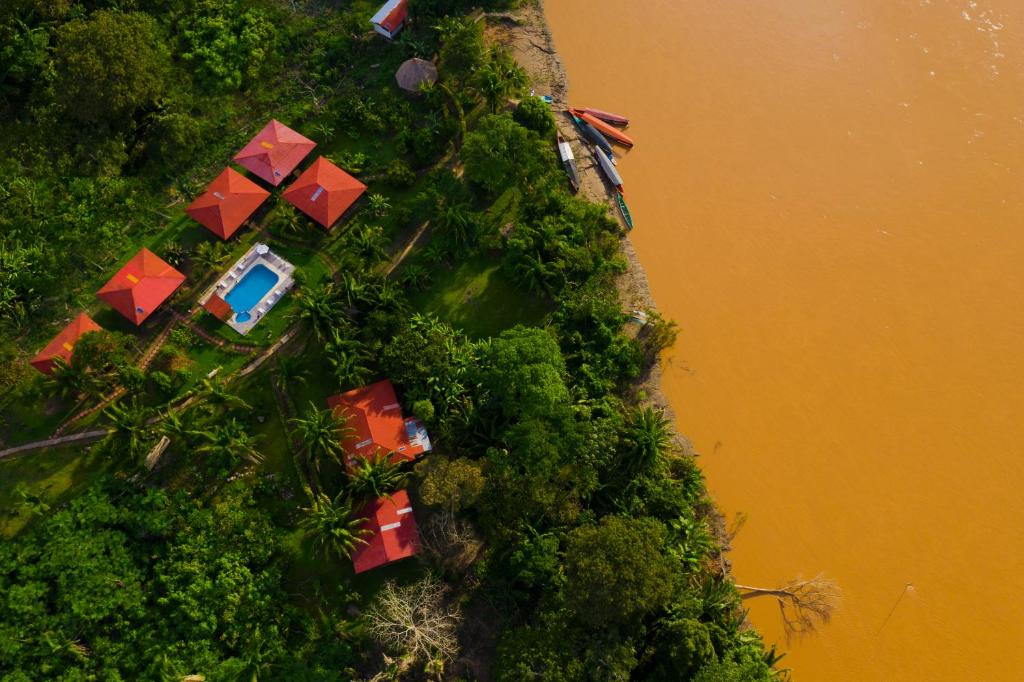 TambopataMonte Amazonico Lodge的享有山丘的树木和水面景色