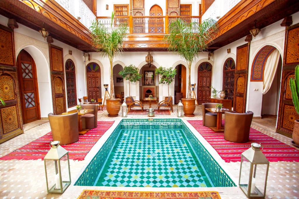 马拉喀什梅尔霍恩摩洛哥传统庭院旅馆及Spa的一座带桌椅的室内游泳池