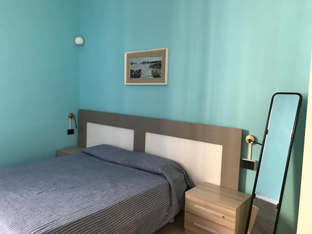 克雷莫纳Appartamento Gloria的一间卧室设有一张床和蓝色的墙壁