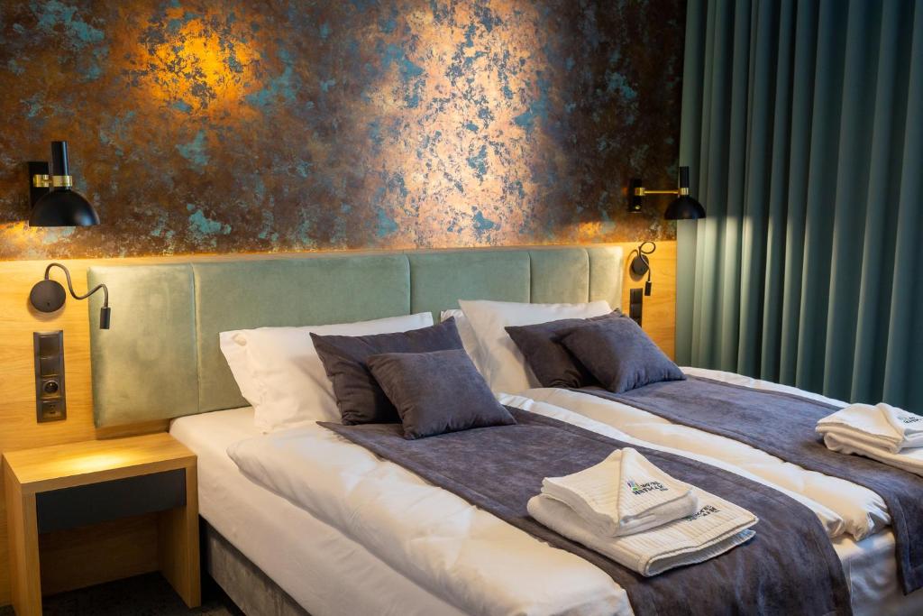 谢德尔采Hotel & SPA Hetman的两张位于酒店客房的床,拥有蓝色的墙壁