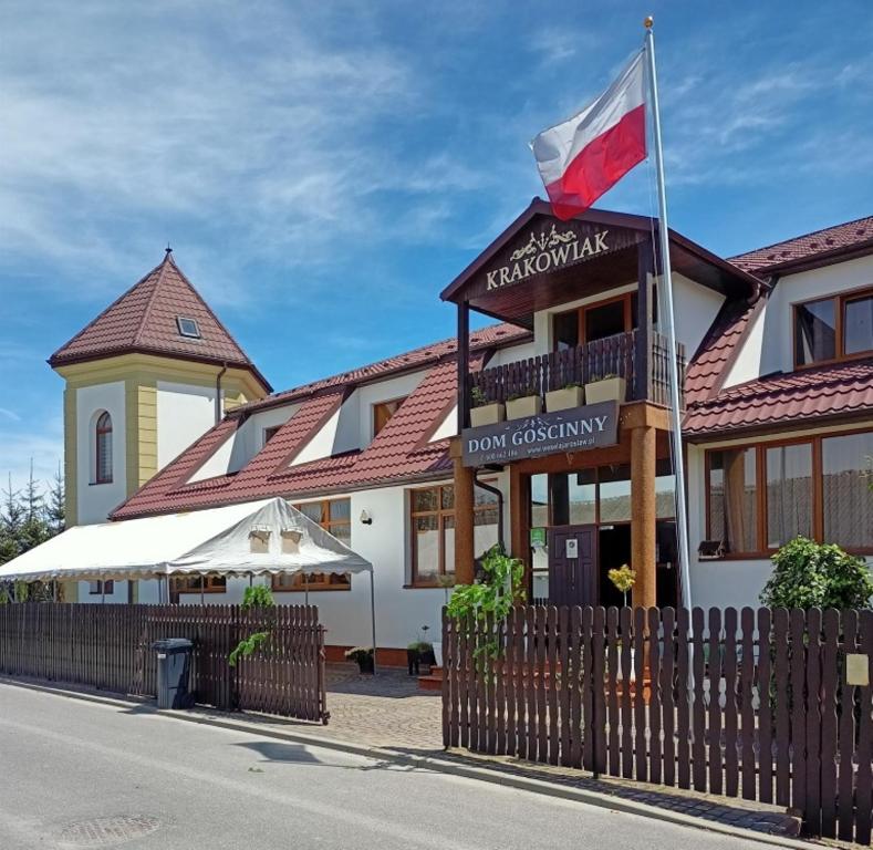 雅罗斯瓦夫Hotelik Krakowiak的上面有旗帜的建筑