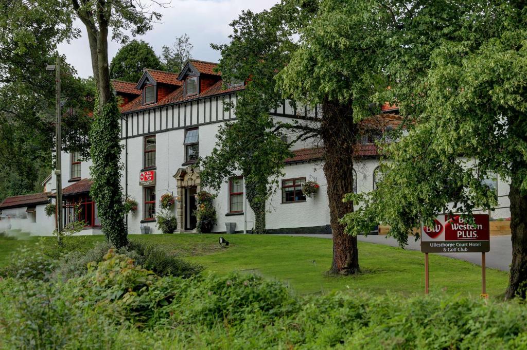 拉特沃思贝斯特韦斯特普拉斯乌勒斯托普法院酒店&高尔夫俱乐部的前面有树木的白色建筑