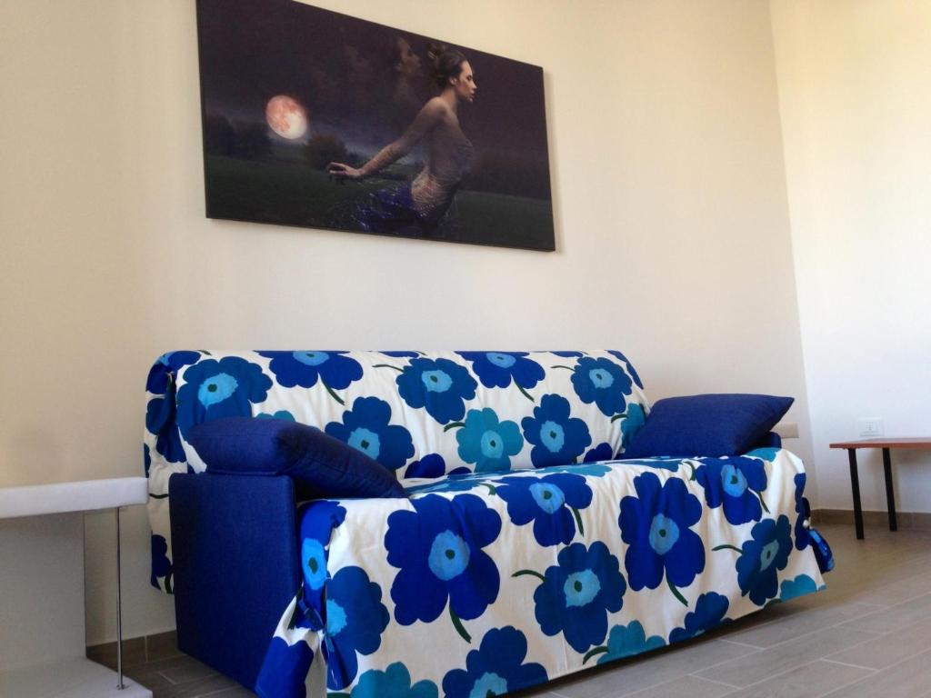 加利波利Casa Ombry Gallipoli的客厅里一张蓝色的沙发,上面有蓝色的鲜花