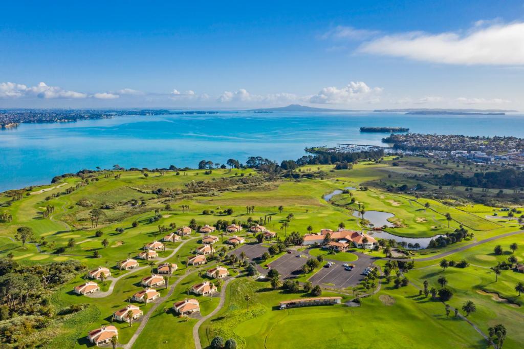 奥克兰Rydges Formosa Auckland Golf Resort的享有高尔夫球场和大海的空中景致