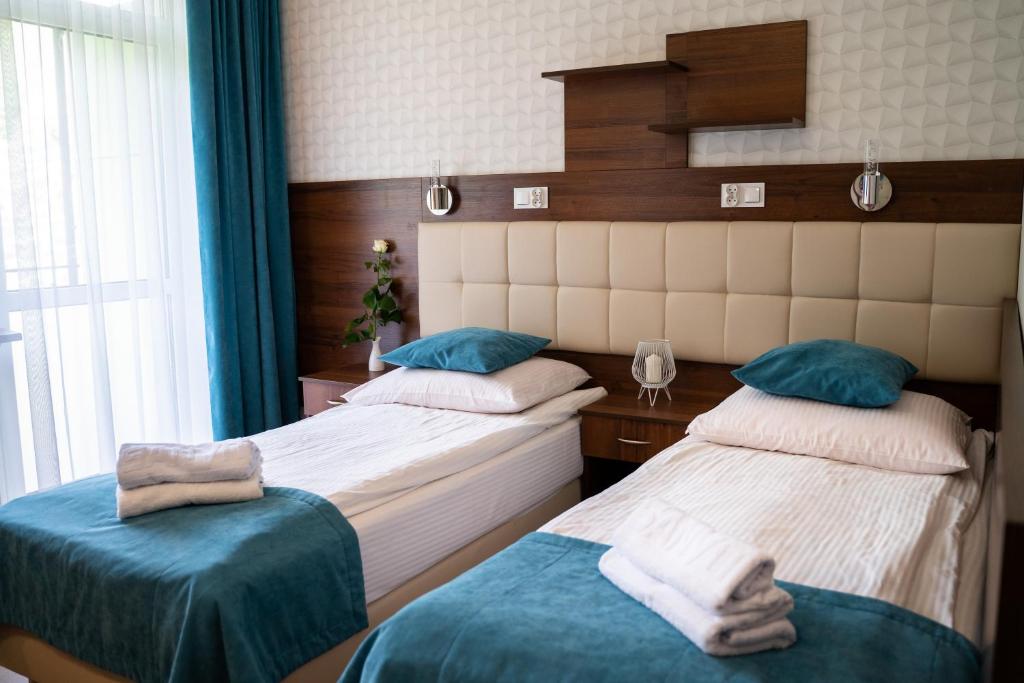 伊沃尼奇-兹德鲁伊Centrum Promocji Zdrowia Sanvit的一间卧室设有两张床和窗户。