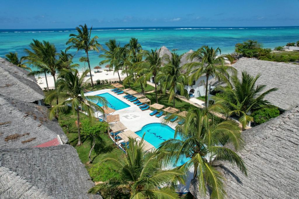 MakunduchiNest Style Beach Hotel Zanzibar的享有棕榈树和海洋度假村的空中景致