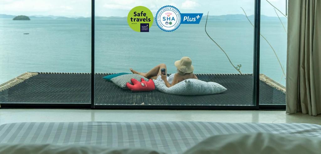 波湾8IK88 Resort - SHA Extra Plus的女人躺在床上的毛巾里