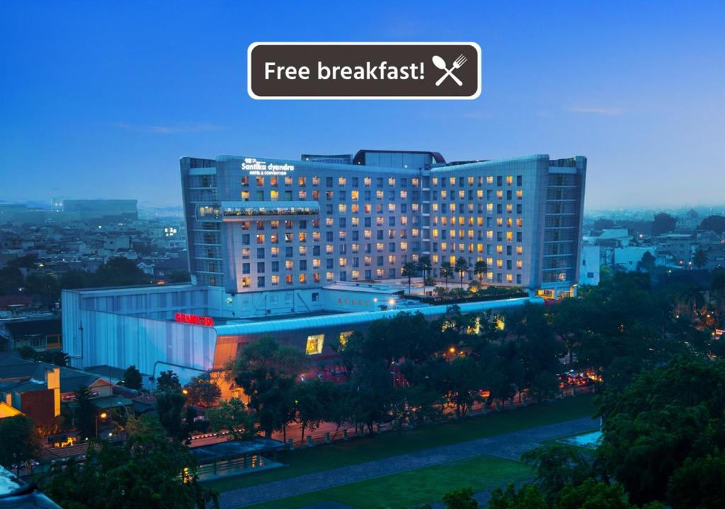 棉兰棉兰S山蒂卡首映酒店及会议的一座大型建筑,上面有免费早餐标志
