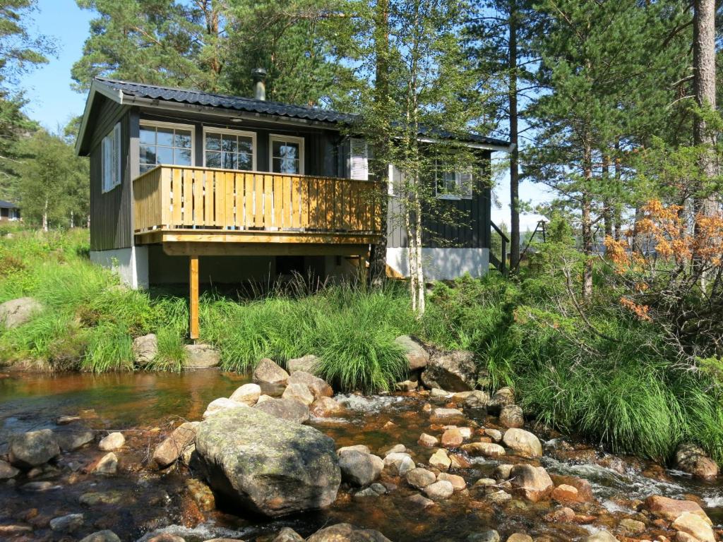 ØyuvstadChalet Sandrabu - SOW056 by Interhome的溪边树林中的房屋