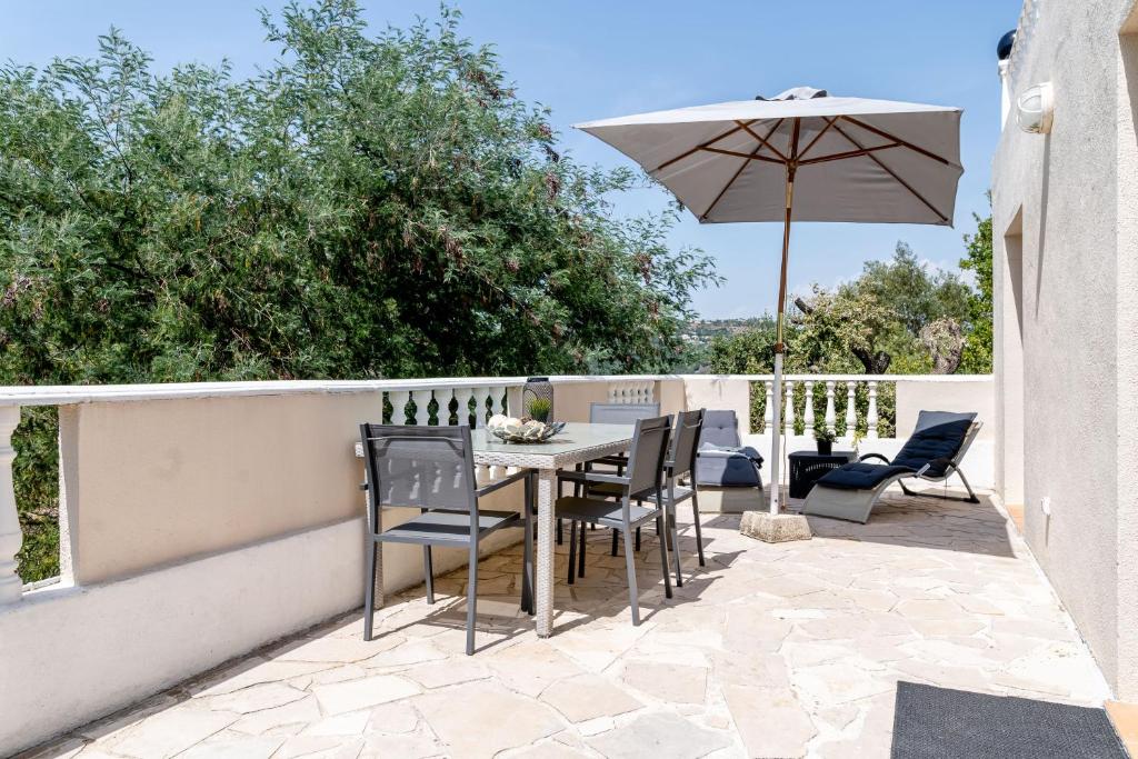 弗雷瑞斯Le Grand Thao的庭院配有桌椅和遮阳伞。