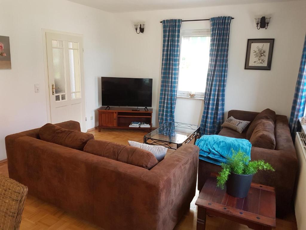Ferienhäusle vom Hof Chirphendorf的客厅配有2张棕色沙发和平面电视。