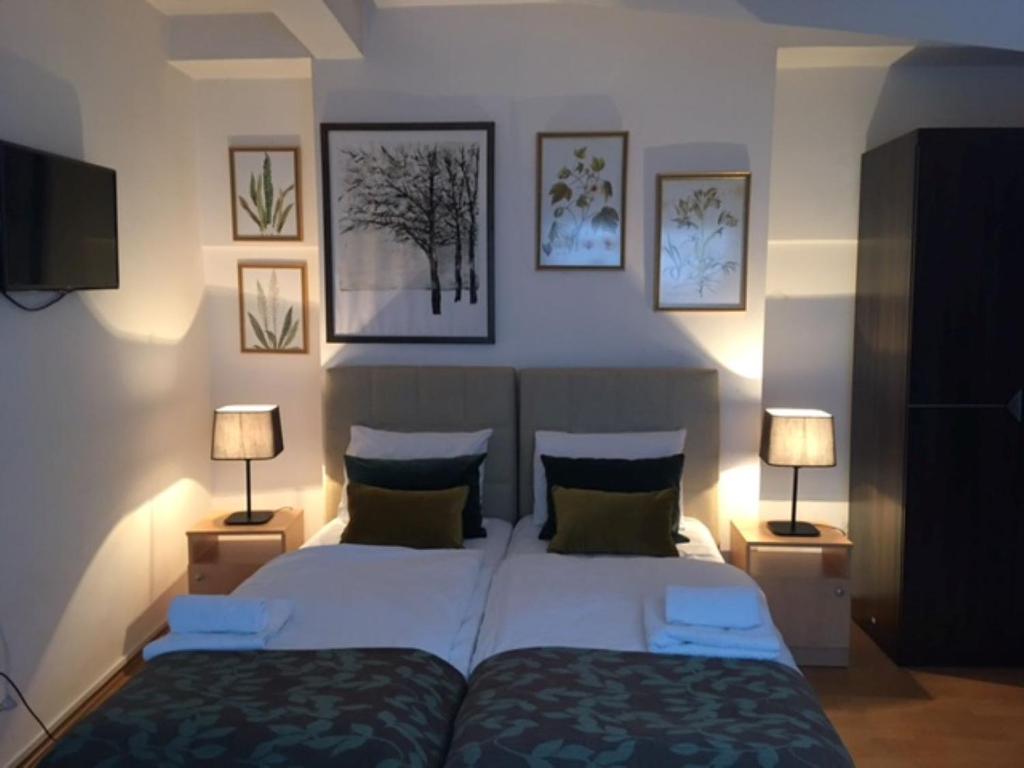 萨拉热窝科尔诺酒店的一间卧室配有两张床和两盏灯。
