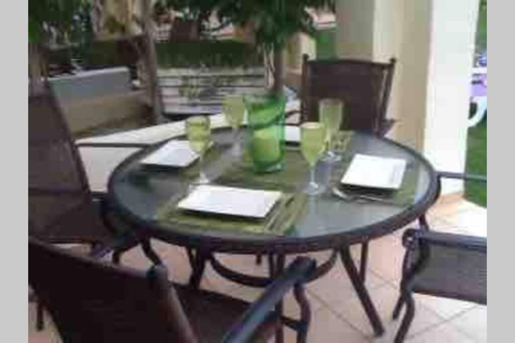 穆尔西亚Roda Golf & Beach Resort. Townhouse, Poolside的一张桌子、两把椅子和一张桌子,上面有饮料