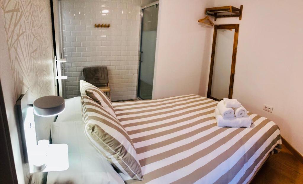 卡塞雷斯El Escondite de la Muralla的一间小卧室,配有带毛巾的床