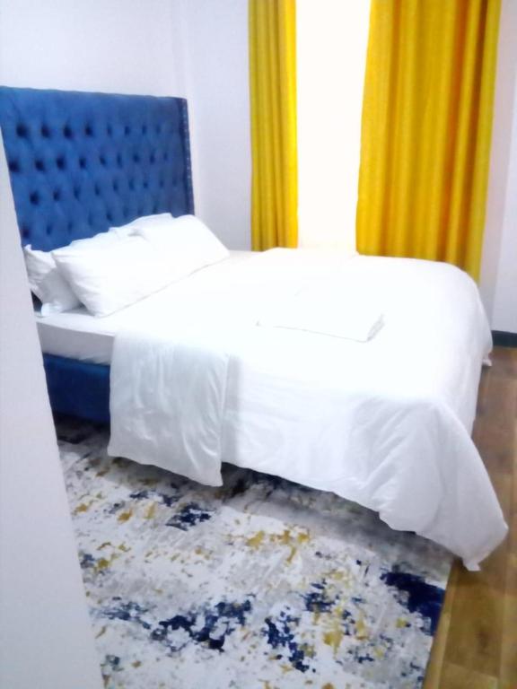 纳库鲁Jacky's Fully Furnished apartments的一间卧室配有一张蓝色床头板的床
