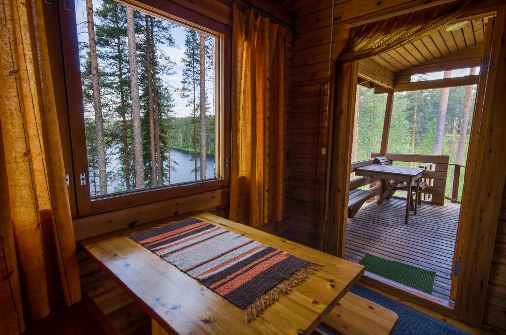 萨里耶尔维Ahvenlampi Camping的小木屋设有桌子和窗户。