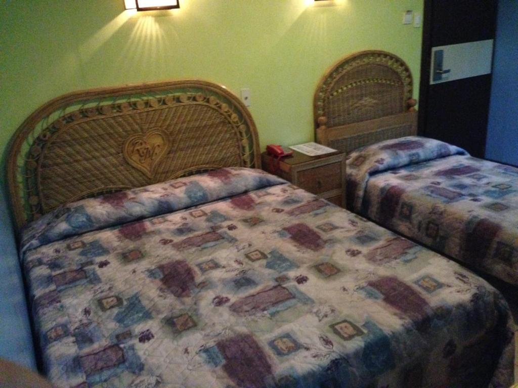 杜马格特RM宾馆的一间卧室配有两张床,床上配有床罩