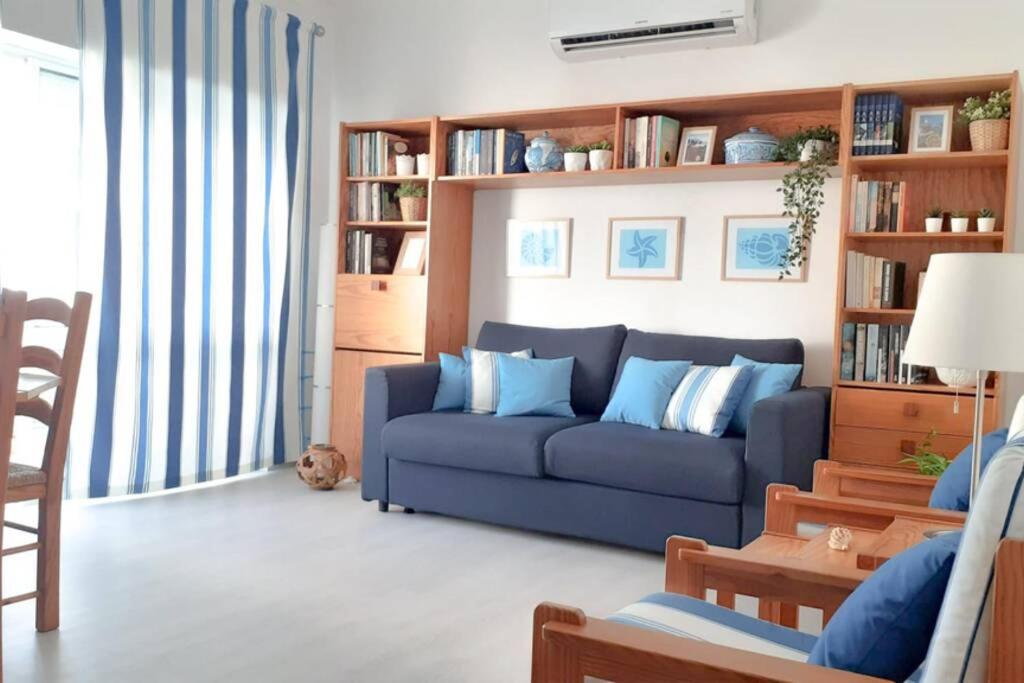 波尔蒂芒Cozy beach front apartment的客厅配有蓝色的沙发和书架