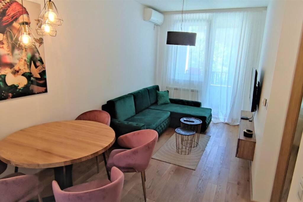 诺维萨德SNP city center lux的客厅配有绿色沙发、桌子和椅子