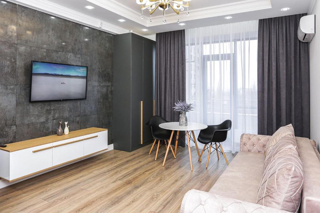 基希讷乌DOUBLE SkyHouse Exclusive Apartments的客厅配有沙发和墙上的电视
