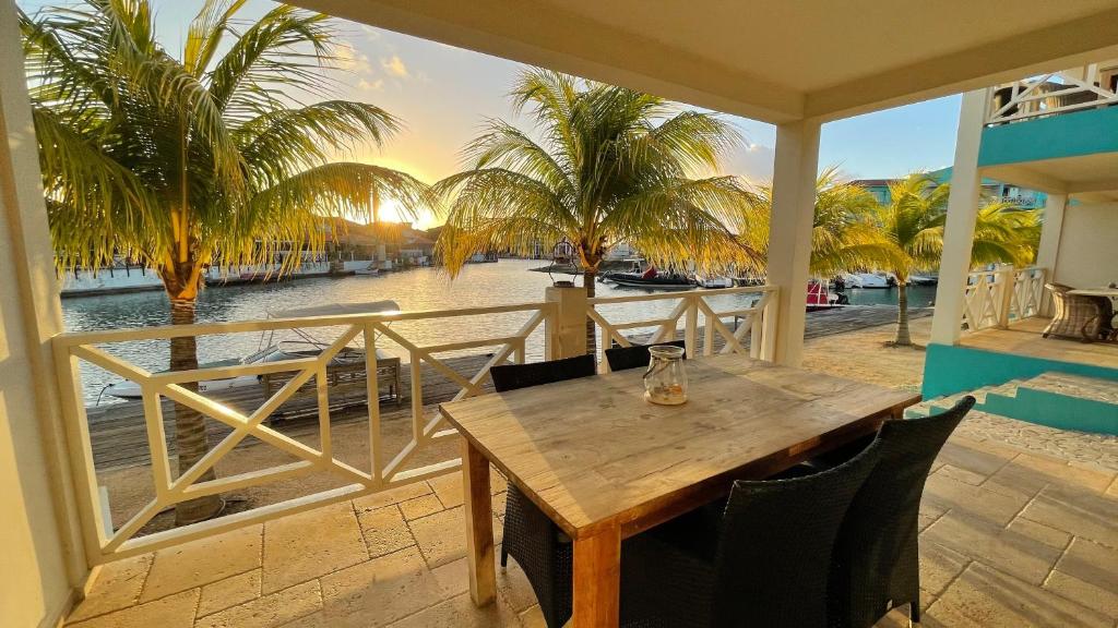 克拉伦代克Caribbean Lofts Bonaire的阳台上的木桌享有水景
