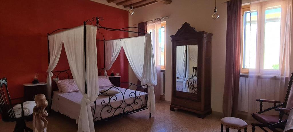 PetrignanoIl Nido del Cuculo的一间卧室配有天蓬床和镜子
