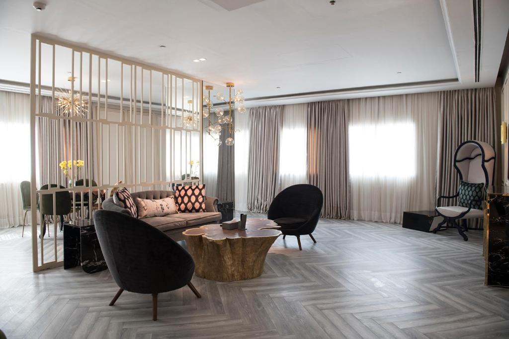 拉合尔尼莎乔哈尔镇酒店的客厅配有沙发、椅子和桌子