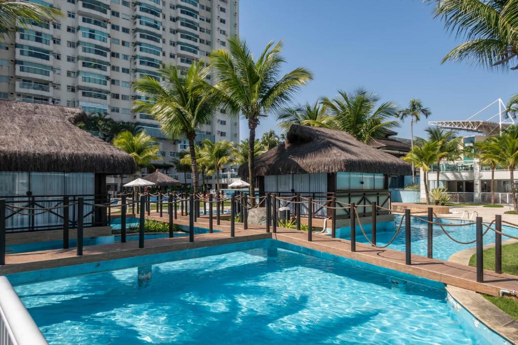 里约热内卢Bora Bora Resort Barra da Tijuca的棕榈树和建筑的度假村游泳池