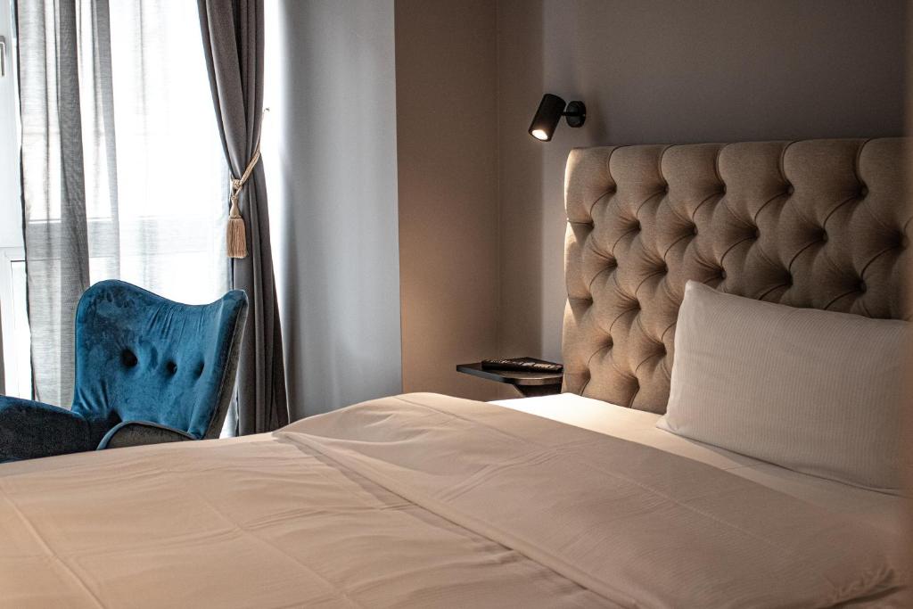 勒沃库森Nikii City Hotel的靠窗的一张带蓝色椅子的床
