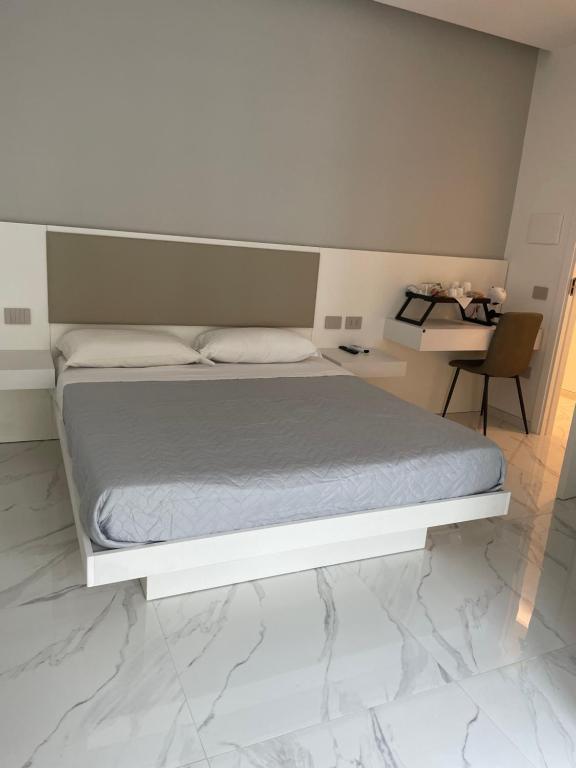 克罗托内B & B La casa di Bianca Luxury的卧室配有白色的床和书桌