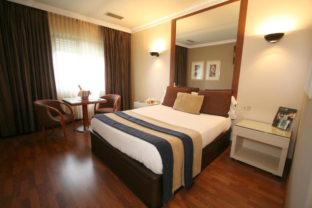 维戈机场汽车旅馆的酒店客房配有一张床铺和一张桌子。
