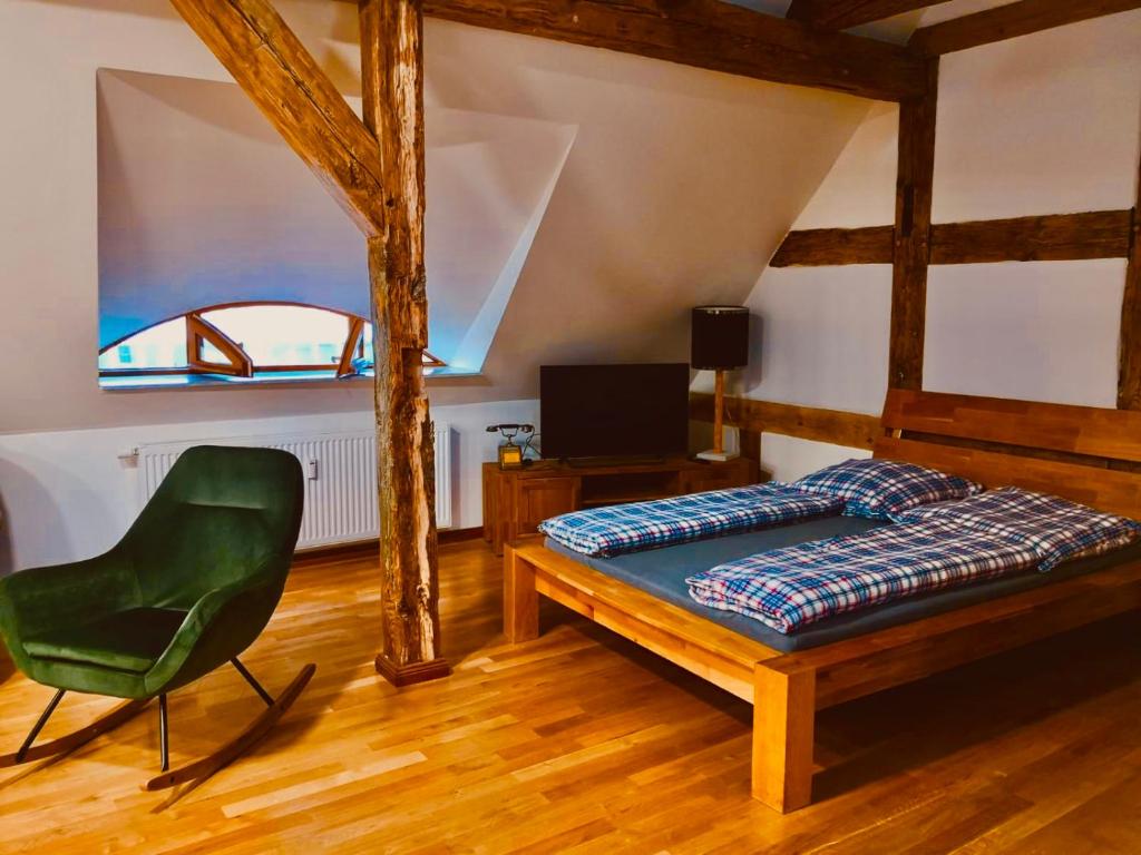埃伯斯瓦尔德菲诺Historisches Ambiente mitten im Zentrum的一间卧室配有一张床和一把绿色椅子