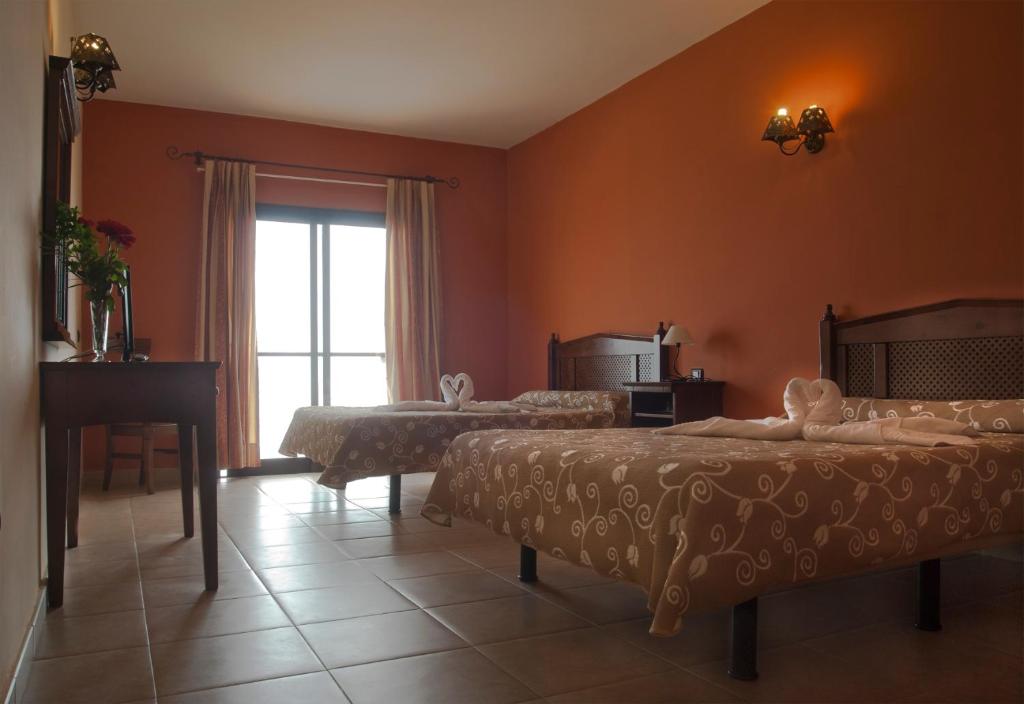 莫卡诺尔Hotel Villa El Mocanal的酒店客房设有两张床和窗户。