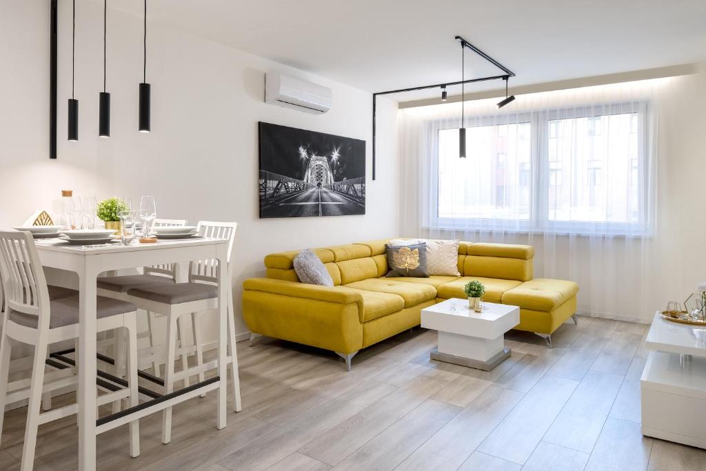 杰尔Divat Apartments - Central Smart Homes的客厅配有黄色的沙发和桌子
