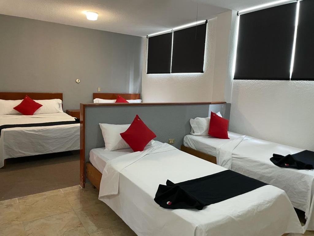 阿瓜斯卡连特斯HOTEL SiCILIA iTALIA的酒店客房 - 带两张带红色枕头的床