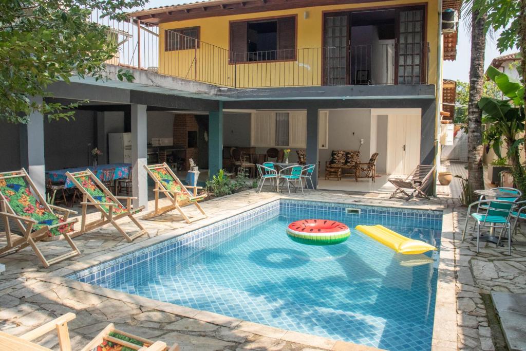 帕拉蒂Hostel Morada do sol Paraty的一个带椅子的游泳池以及一座房子