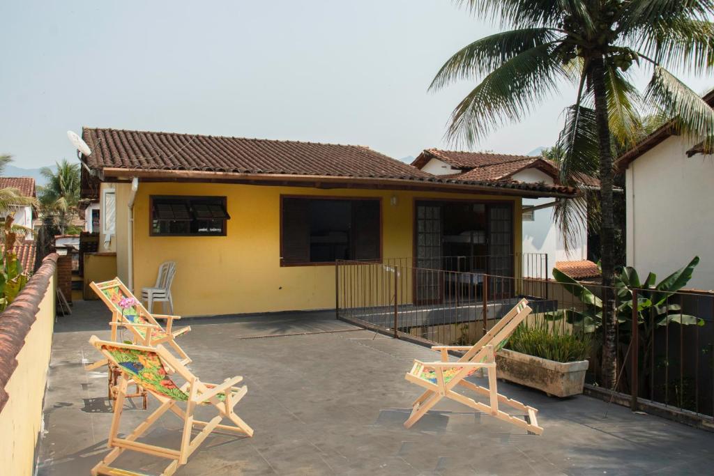 帕拉蒂Hostel Morada do sol Paraty的两把椅子坐在房子前面的庭院
