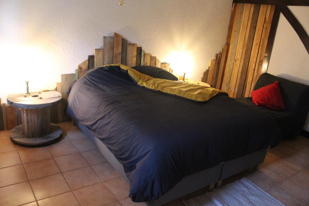 马尔梅迪Bois & Repos的一间卧室配有一张大床和木制床头板