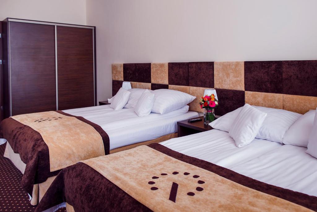 罗兹一号精品酒店的一间酒店客房,配有两张床和鲜花