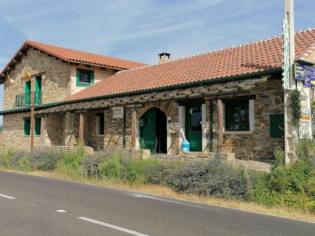 Murias de Rechivaldo弗洛尔旅馆的一座石头建筑,设有红色屋顶和绿门