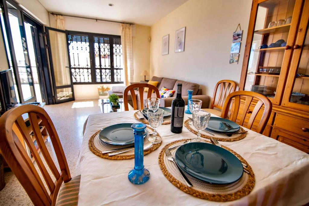 厄尔梅达诺Alquilaencanarias- Medano spectacular terrace and sea views B的用餐室配有带盘子和酒杯的桌子