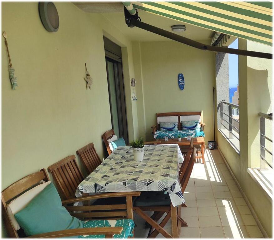厄尔梅达诺Residencial Los Patios Playa Medano Windsurf zone的阳台的用餐室配有桌椅