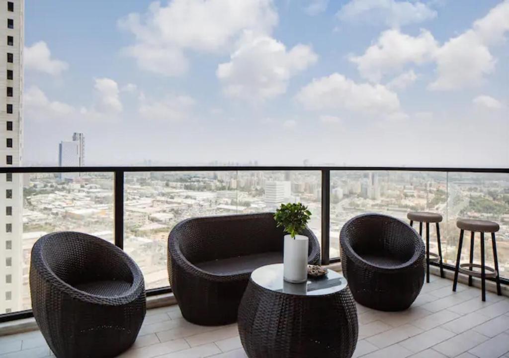 巴特亚姆O&O Group- Special Apartment Sea View Luxury Tower的阳台配有桌椅和大窗户。
